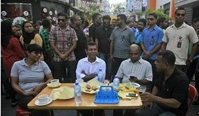 Популярный экс-президент Мохамед Нашид (в центре) беседует со своими сторонниками, перекрывшими главную улицу столицы.