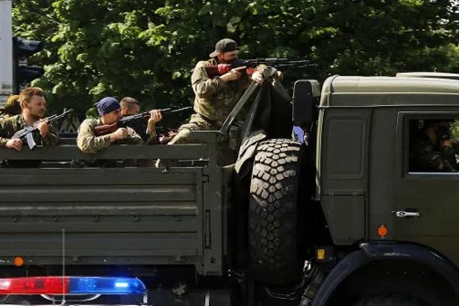 Ваенны грузавік з ўзброенымі прарасейскімі баевікамі праязджае кантрольна-прапускны пункт да аэрапорта. Фота Reuters