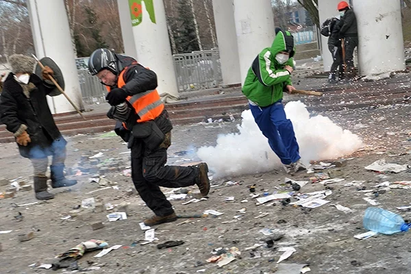 Сергей Гриц (на фото в центре) на улице Грушевского, на самой линии огня. Слева от него — крестьянин из-под Черновцов Гаврилюк, который в тот же день станет объектом издевательств спецназа. Справа — разрывается граната. Фото Франс пресс.