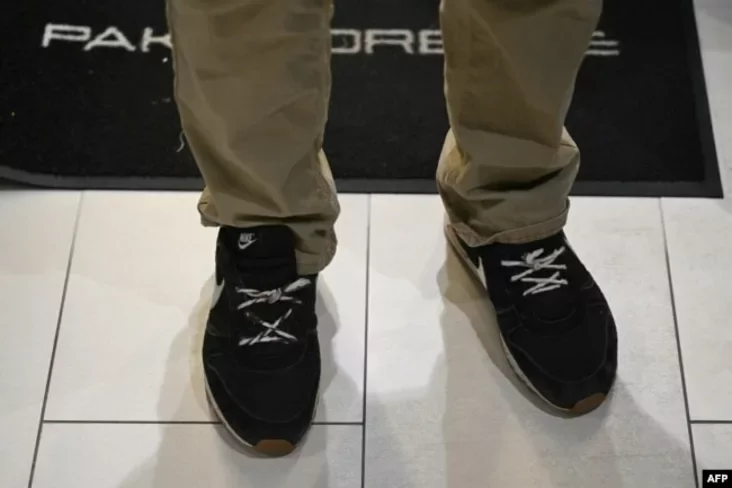 Ales Bialiatski uses shoelaces instead of laces at a shopping center in Vilnius a day after his release. He was arrested, convicted, and released from prison in these sneakers. Vilnius, December 14, 2025