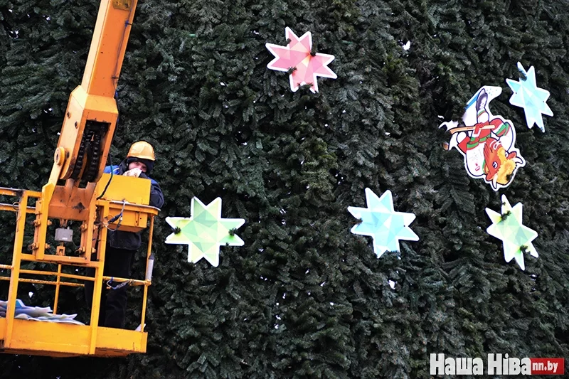 Рабочий снимает украшения с главной белорусской елки на Октябрьской площади. В этом году помимо привычных гирлянд и снежинок елку украсили и изображениями талисмана ЧМ по хоккею по имени Волат.