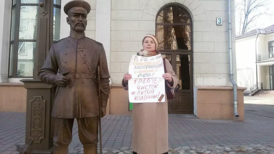 Женщина стоит рядом с недавно установленной скульптурой городового у здания МВД. На плакате надпись «Требуем чистки пятой колонны» и георгиевская ленточка. Фото из фейсбука Дмитрия Галко. 