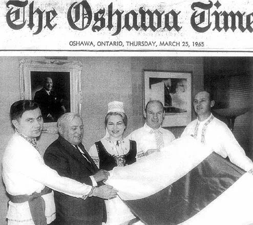  Антон Маркевіч (злева) на чале беларускае грамады ўручае бел-чырвона-белы сцяг мэру Ашавы Лайману Хіфарду, гэтую падзею Oshawa Times вынесла на першую старонку.