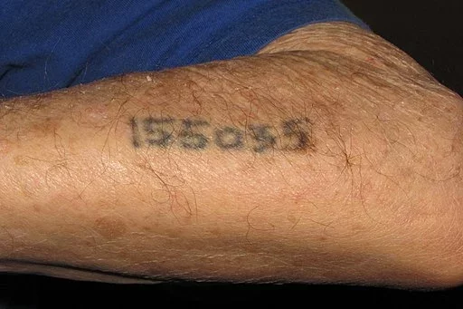 Татуировка на руке бывшего узника Освенцима. Фото Wikimedia Commons.
