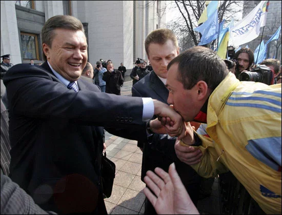 Małady prychilnik Janukoviča całuje ruku svajmu lideru.