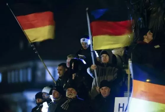 Участники митинга в Дрездене с национальными флагами. Фото Reuters.