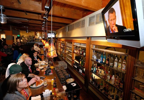 Посетители бара в штате Юта смотрят передачу с участием Опры Уинфри и Лэнса Армстронга.