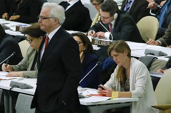 Представитель США в ООН Саманта Пауэр проверяет телефон, в то время как представитель России Виталий Чуркин проходит мимо, а представитель Беларуси что-то пишет, фото Рейтер