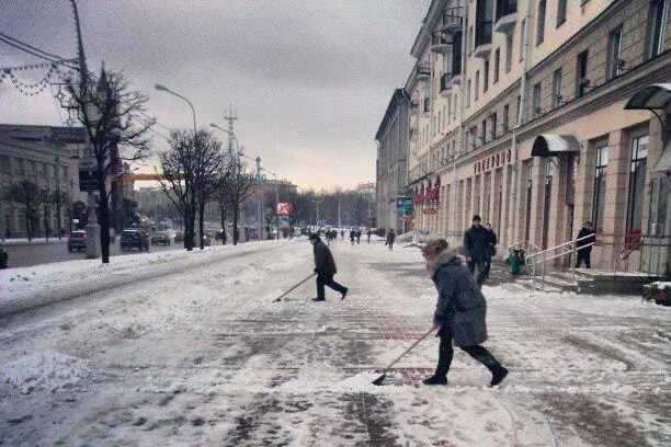 Минск. Сотрудники магазина убирают снег на проспекте утром. Фото Сергея Гудилина.