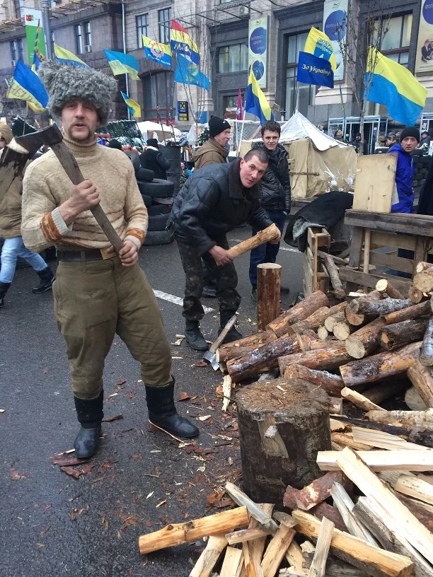 На этом фото он рубит дрова на Майдане.