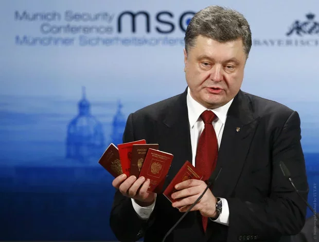 Петр Порошенко показывает российские паспорта в Мюнхене. Фото Рейтер.
