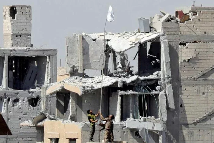 Бойцы Сирийских демократических сил поднимают свой флаг над стадионом, Reuters.com