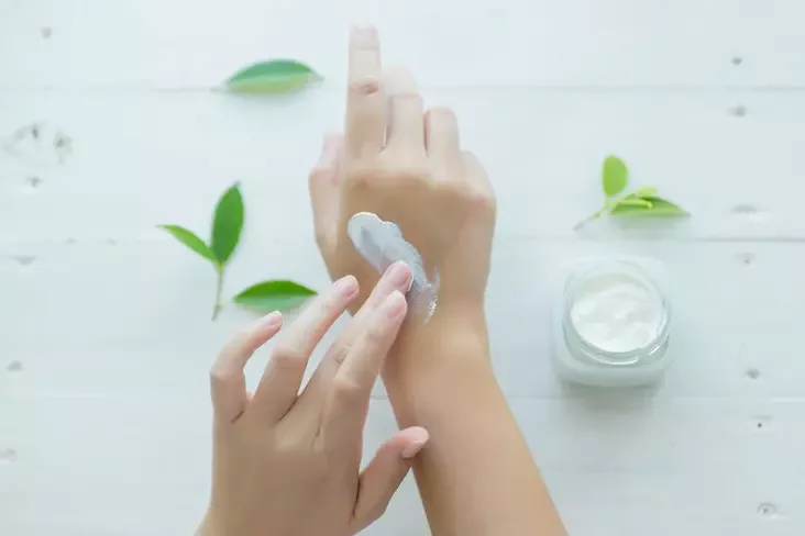 Woman putting cream on her hands