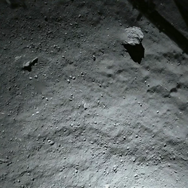 Гэтая фатаграфія зробленая камерай, размешчанай у ніжняй частцы зонда «Филы» 14 лістапада незадоўга да яго пасадкі. Вялікі камень, які на здымку відаць па правым баку і ўверсе, мае дыяметр 5 метраў.
