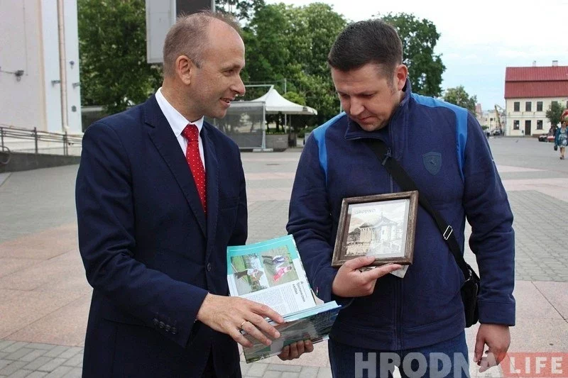 Олег Андрейчик дарить юбилейному безвизовому туристу памятную книгу о Гродненщине.
