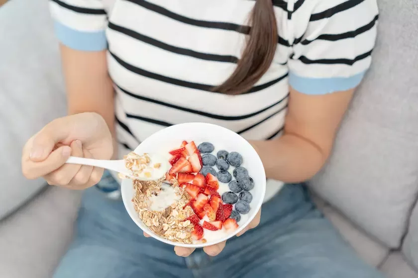 Woman is eating tasty breakfast