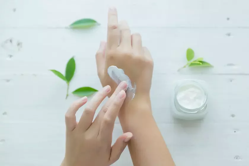 Woman putting cream on her hands