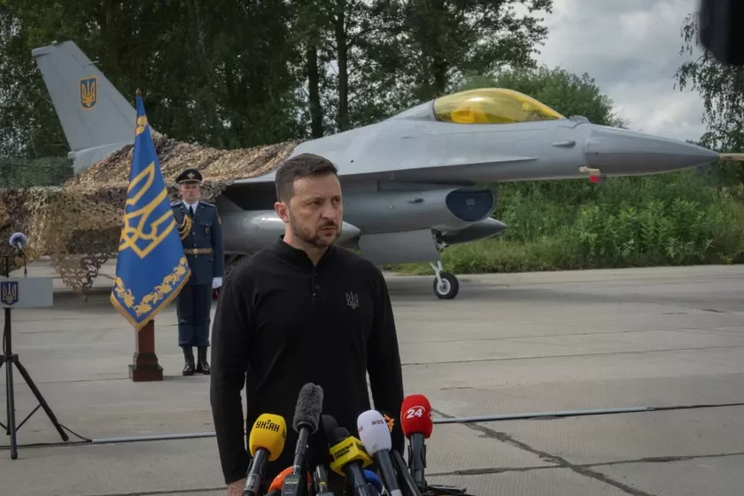 Priezidient Ukrainy Vładimir Zielenskij otviečajet na voprosy ŚMI, stoja na fonie istriebitielej F-16 Vojenno-vozdušnych sił Ukrainy Prezident Ukrainy Uładzimir Zialenski adkazvaje na pytańni ŚMI, stojačy na ​​fonie źniščalnikaŭ F-16 VPS Ukrainy Ukraine's President Volodymyr Zelenskyy answers media questions standing against the background of Ukraine's Air Force's F-16 fighter jets 