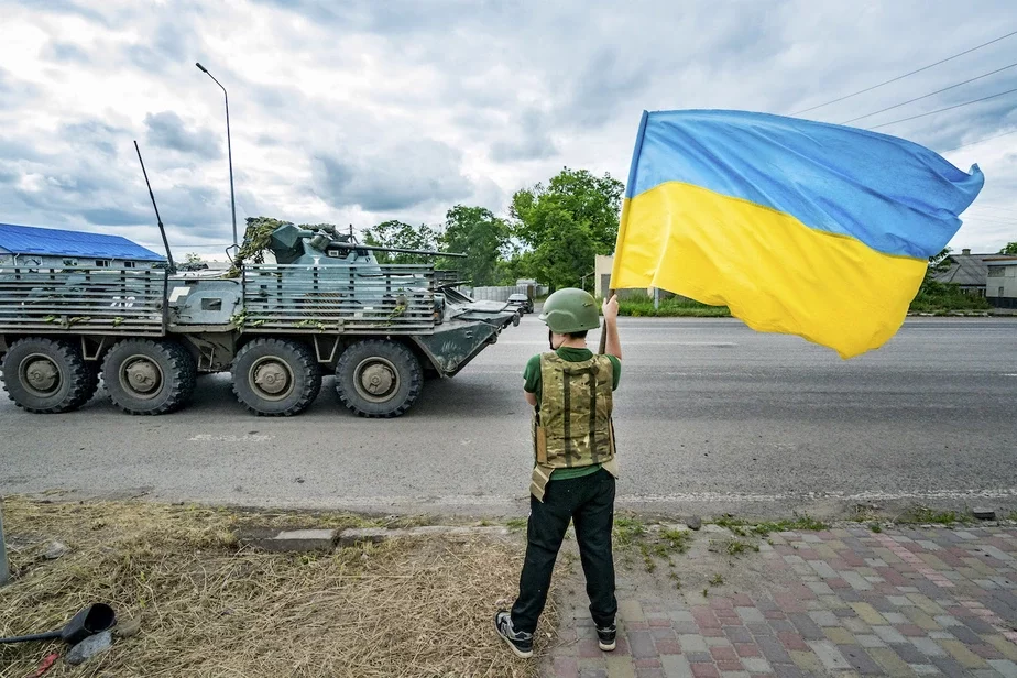 Мальчик размахивает украинским флагом, когда бронетранспортер украинской армии направляется к Бахмутской линии фронта в Славянске, 27 июня 2023 г. Фото: Celestino Arce / NurPhoto via Getty Images