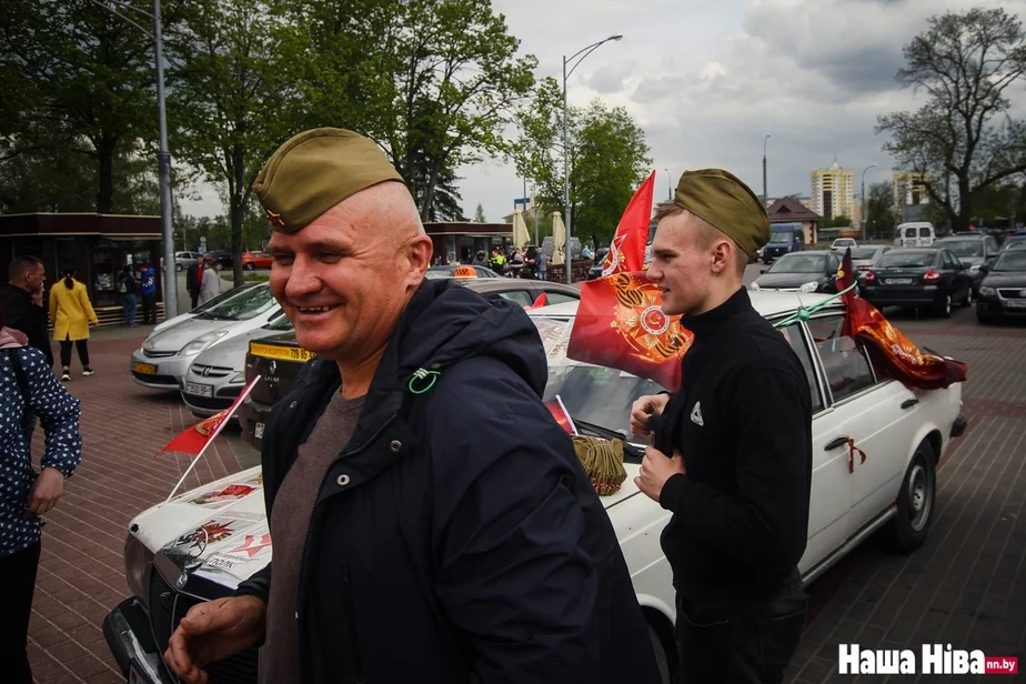 Малады прадпрымальнік (справа) размясціў свой тавар у старым «Мерсэдэсе» на паркоўцы каля Брэсцкай крэпасці. Пажылы турыст купіў у яго пілотку.