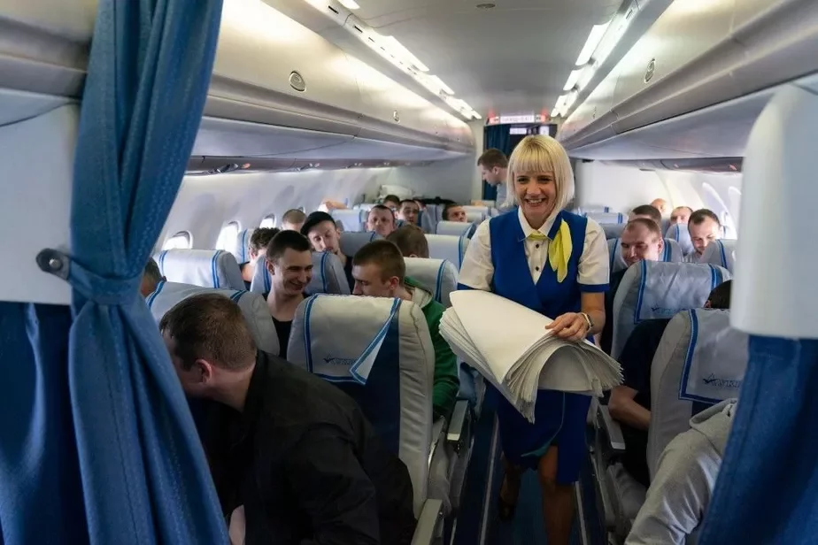 Стюардесса украинского президентского самолета раздает только что освобожденным заключенным салфетки перед завтраком.