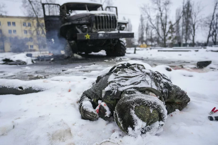 Cieła vajskoŭca zasypana śnieham pobač sa źniščanaj rasiejskaj vajskovaj reaktyŭnaj sistemaj załpavaha ahniu na ŭskrainie Charkava, Ukraina, 25 lutaha 2022 h. Fota: AP 