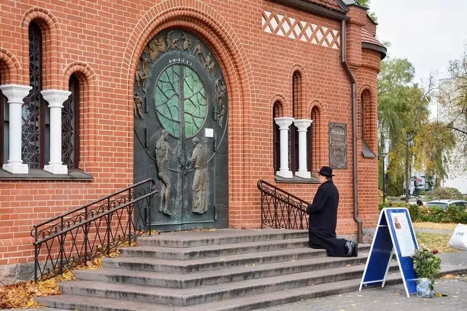 Настоятель Красного костела Владислав Завальнюк молится на крыльце закрытой святыни. Фото Виктора Веденя