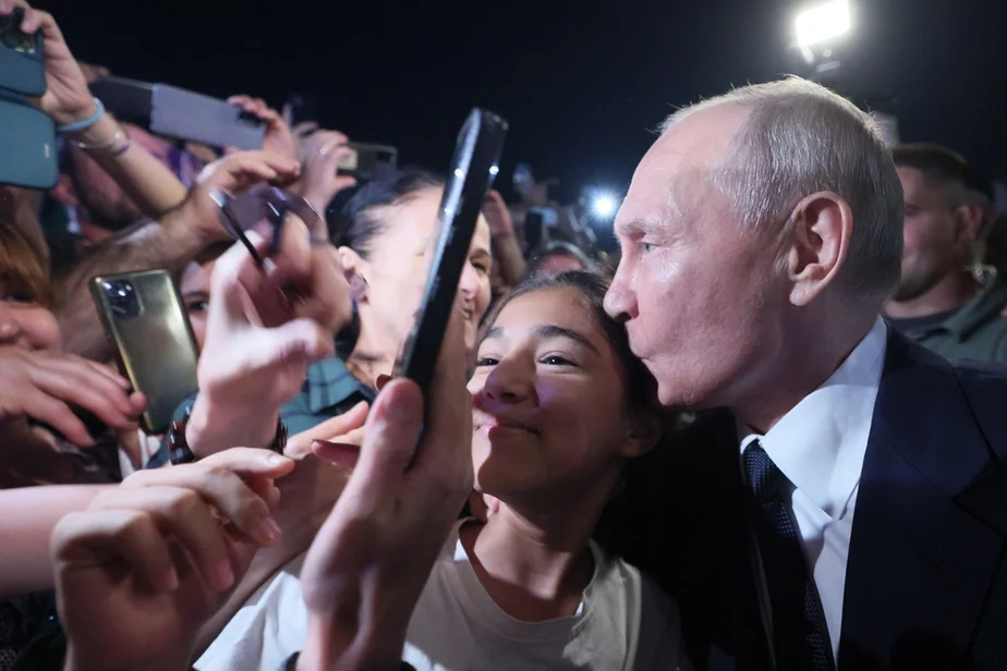 Уладзімір Пуцін у Дзербенце абдымае незнаёмую дзяўчынку, якая папрасіла з ім сфатаграфавацца. Фота: Gavriil Grigorov, Sputnik, Kremlin Pool Photo via AP