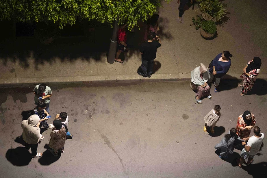 Людзі хаваюцца і правяраюць навіны на сваіх мабільных тэлефонах пасля землятрусу ў Рабаце, Марока, у пятніцу, 8 верасня. Фота: Mosa'ab Elshamy / AP