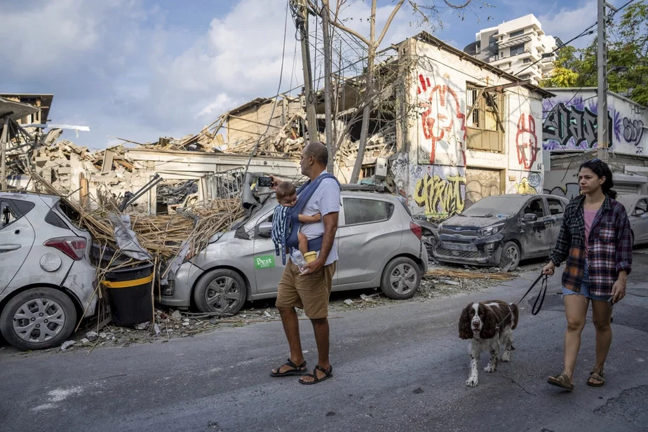 Ізраільцяне аглядаюць завалы будынка праз дзень пасля таго, як у яго трапіла ракета, выпушчаная з сектара Газа, Тэль-Авіў, 8 кастрычніка 2023 г. Фота: Oded Balilty / AP Photo