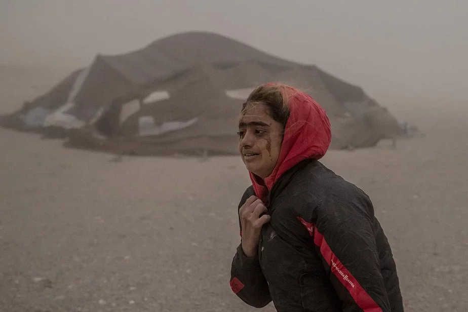 Афганская девушка несет гуманитарную помощь в свою палатку и плачет из-за сильной песчаной бури, произошедшей после землетрясения в районе Зенда-Джан в провинции Герат, на западе Афганистана. Фото: Ebrahim Norooz / AP